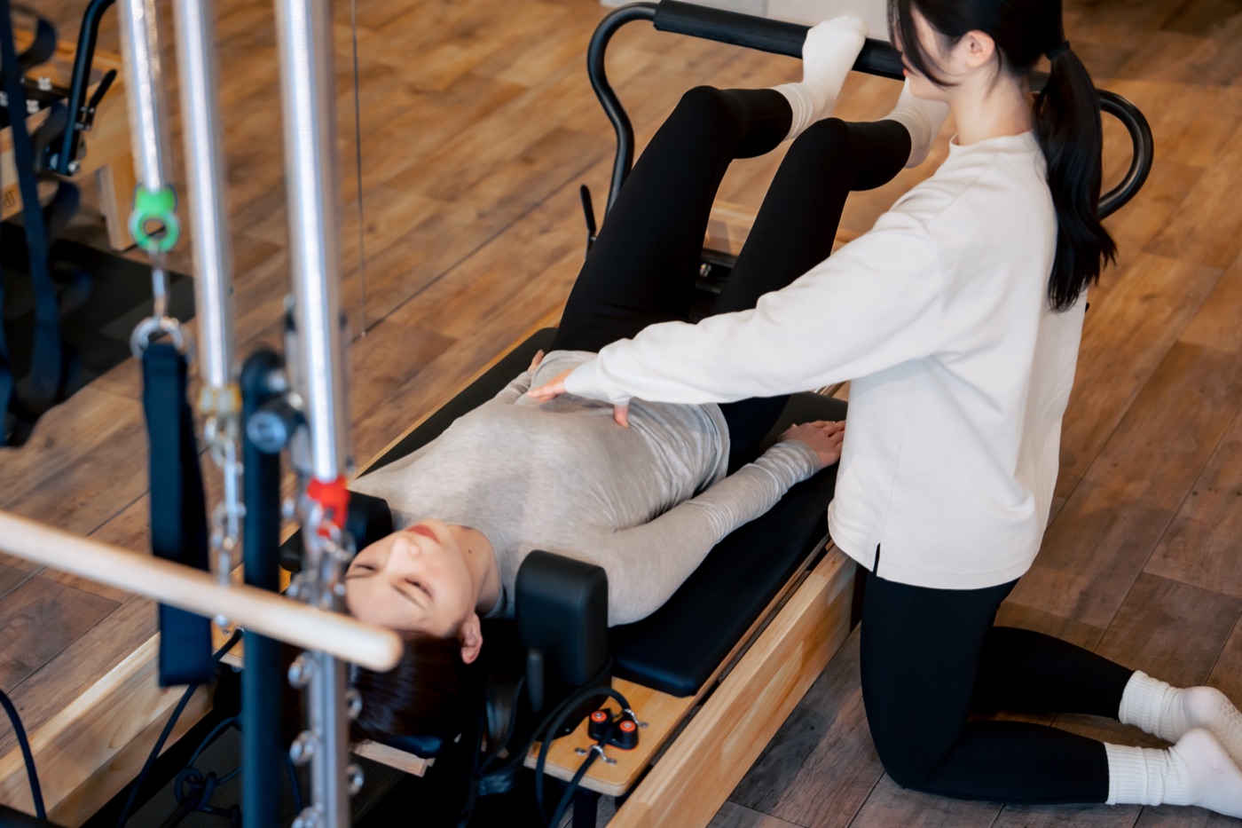 トレーナーが呼吸に合わせて肋骨の動きをサポートしている様子